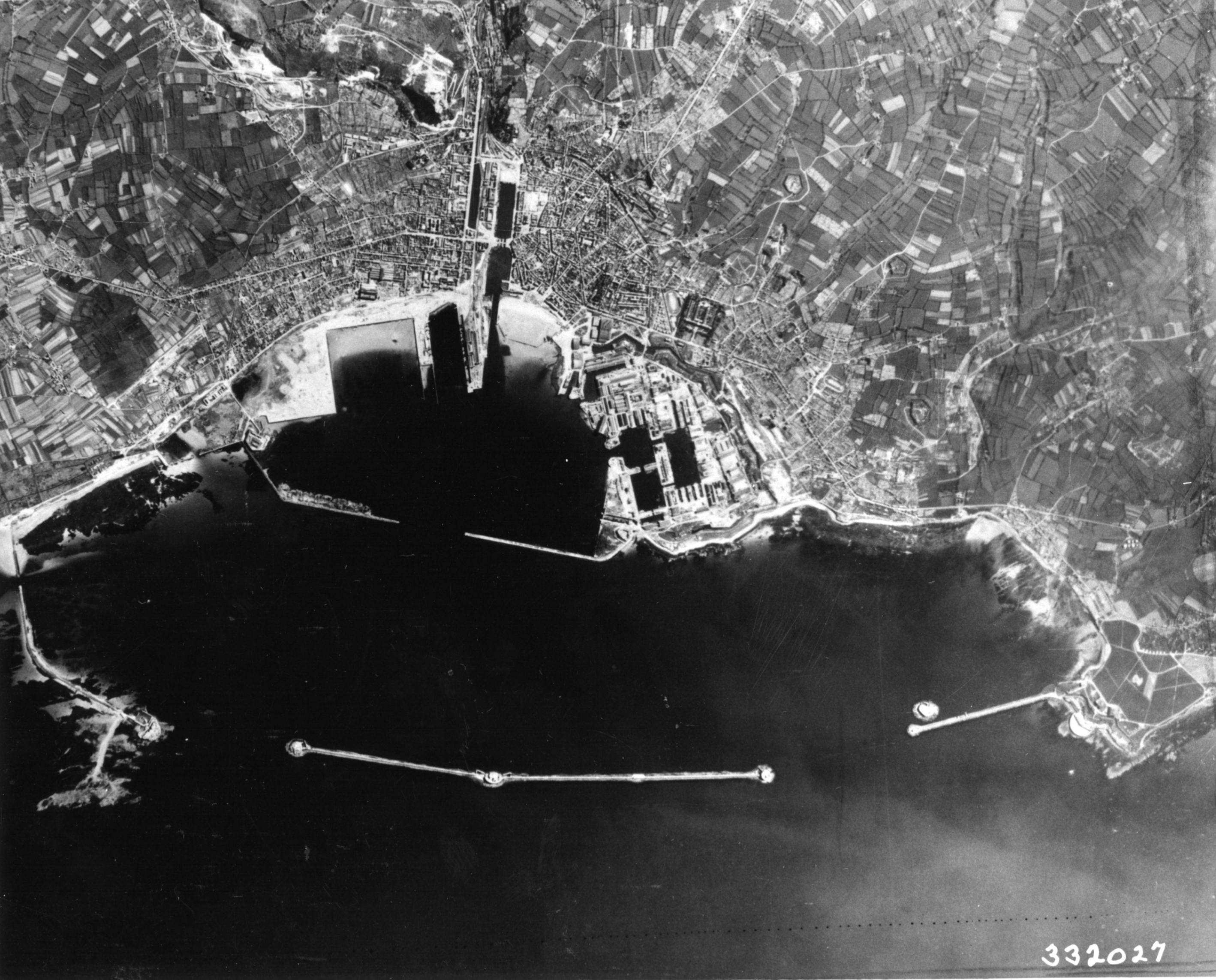Aerial reconnaissance provided this high-altitude photograph of Cherbourg Harbor. Notice the extensive port facilities and harbor defenses. (U.S. Navy) Aerial reconnaissance provided this high-altitude photograph of Cherbourg Harbor. Notice the extensive port facilities and harbor defenses. (U.S. Navy)